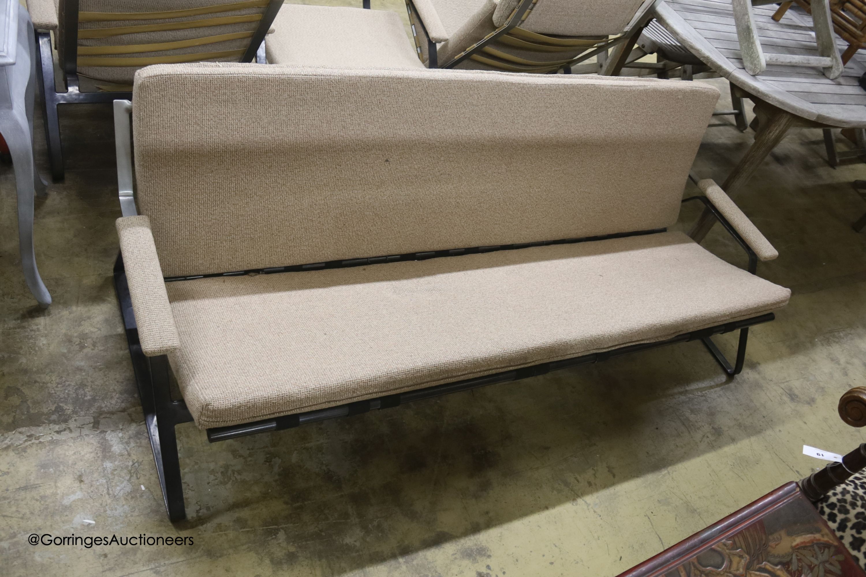 A mid century design wrought metal four piece lounge suite, comprising sofa, length 180cm, chair, rocking chair and a stool